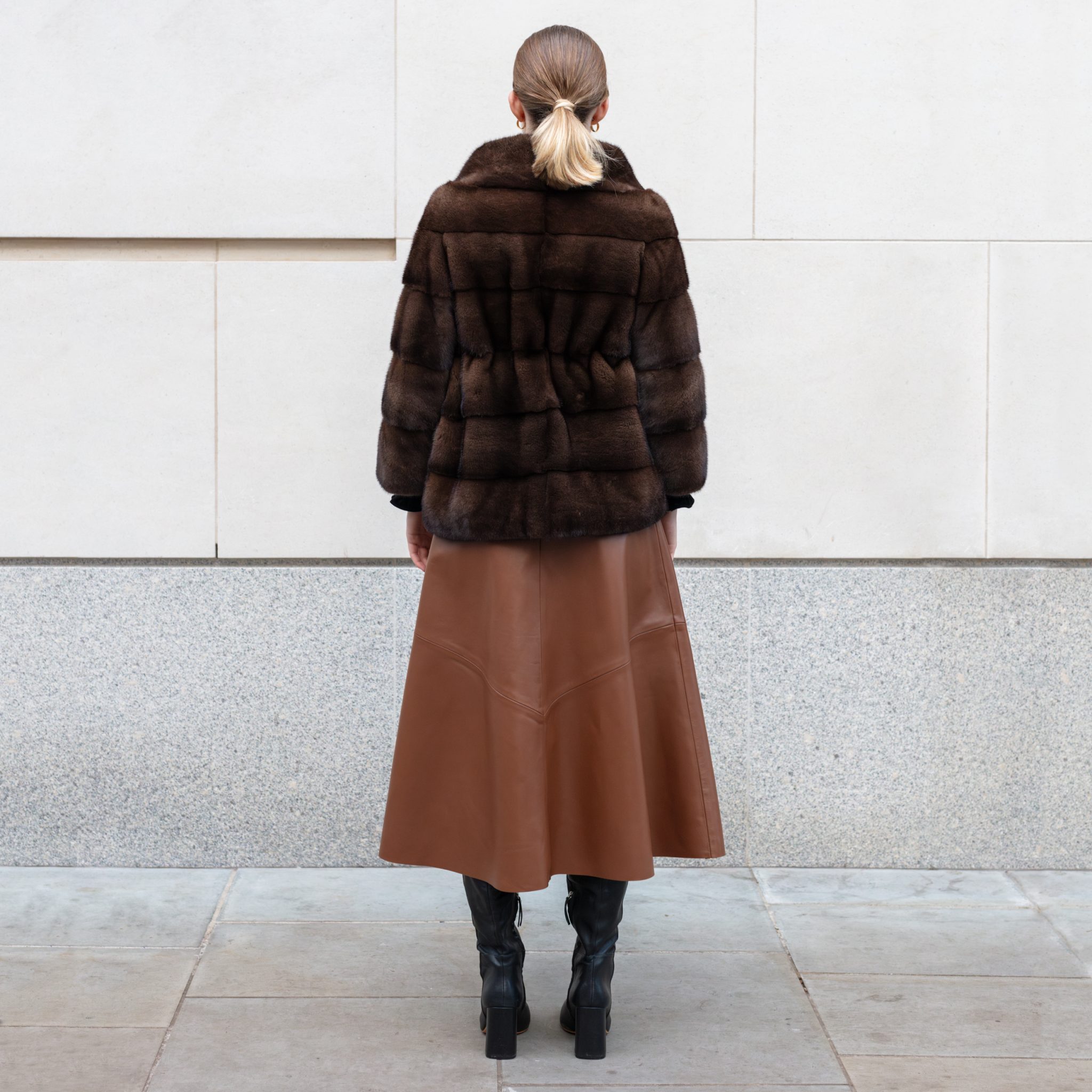 Woman in brown fur coat and faux leather skirt night out